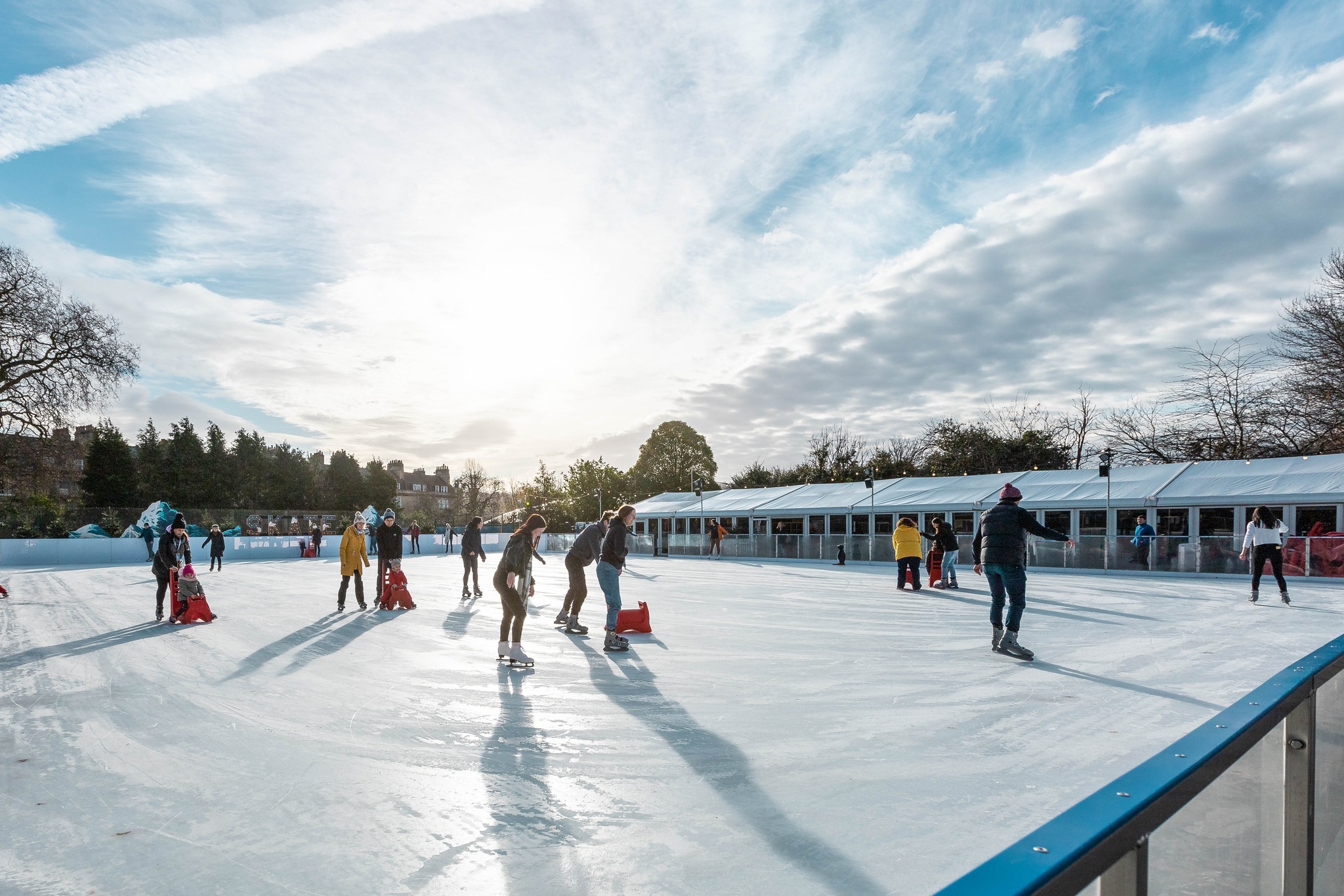 The sun shining on the outdoor winter real ice rink at Bath on Ice. 