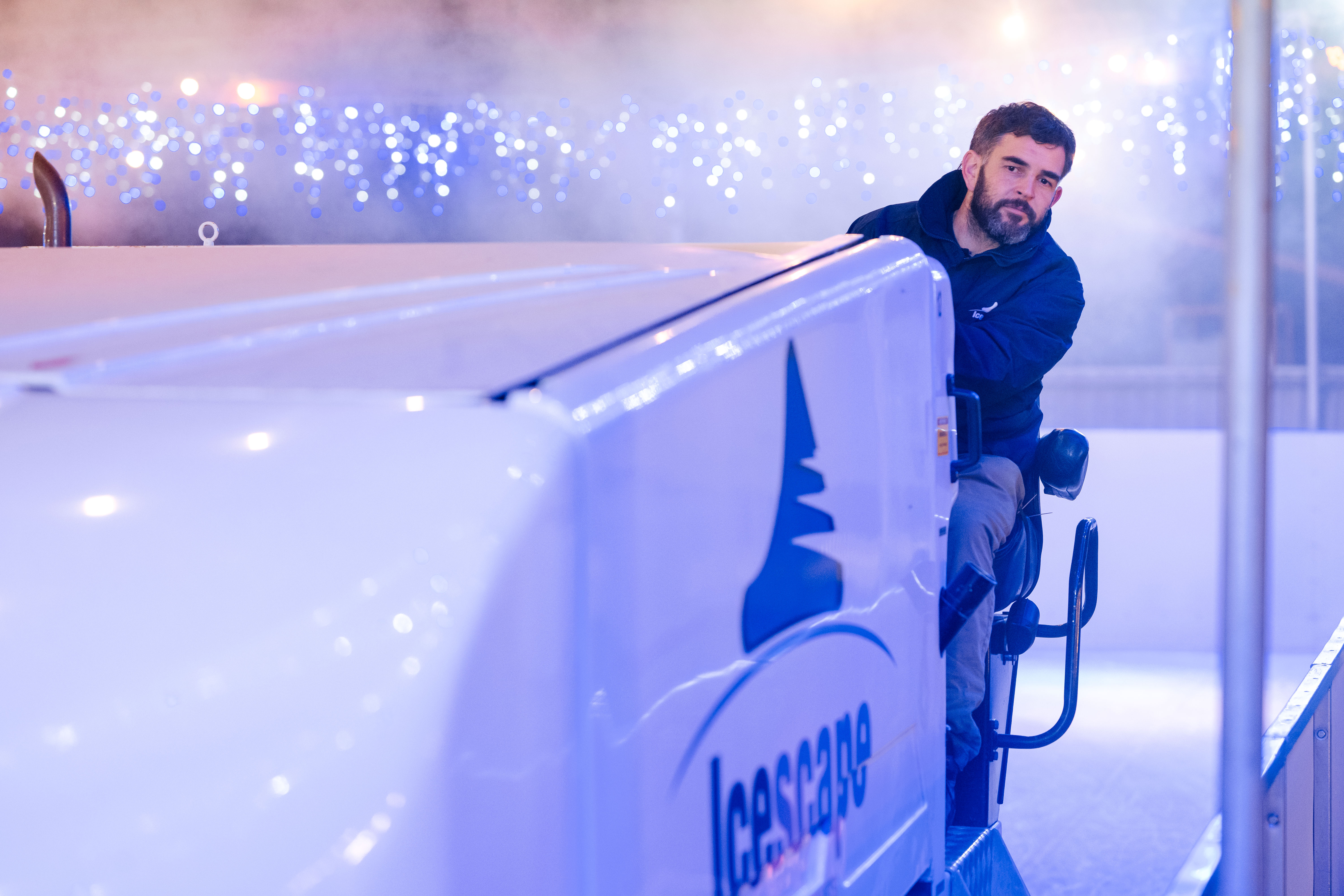 Icescape staff member driving the ice resurfacer on a Christmas Ice Rink. 