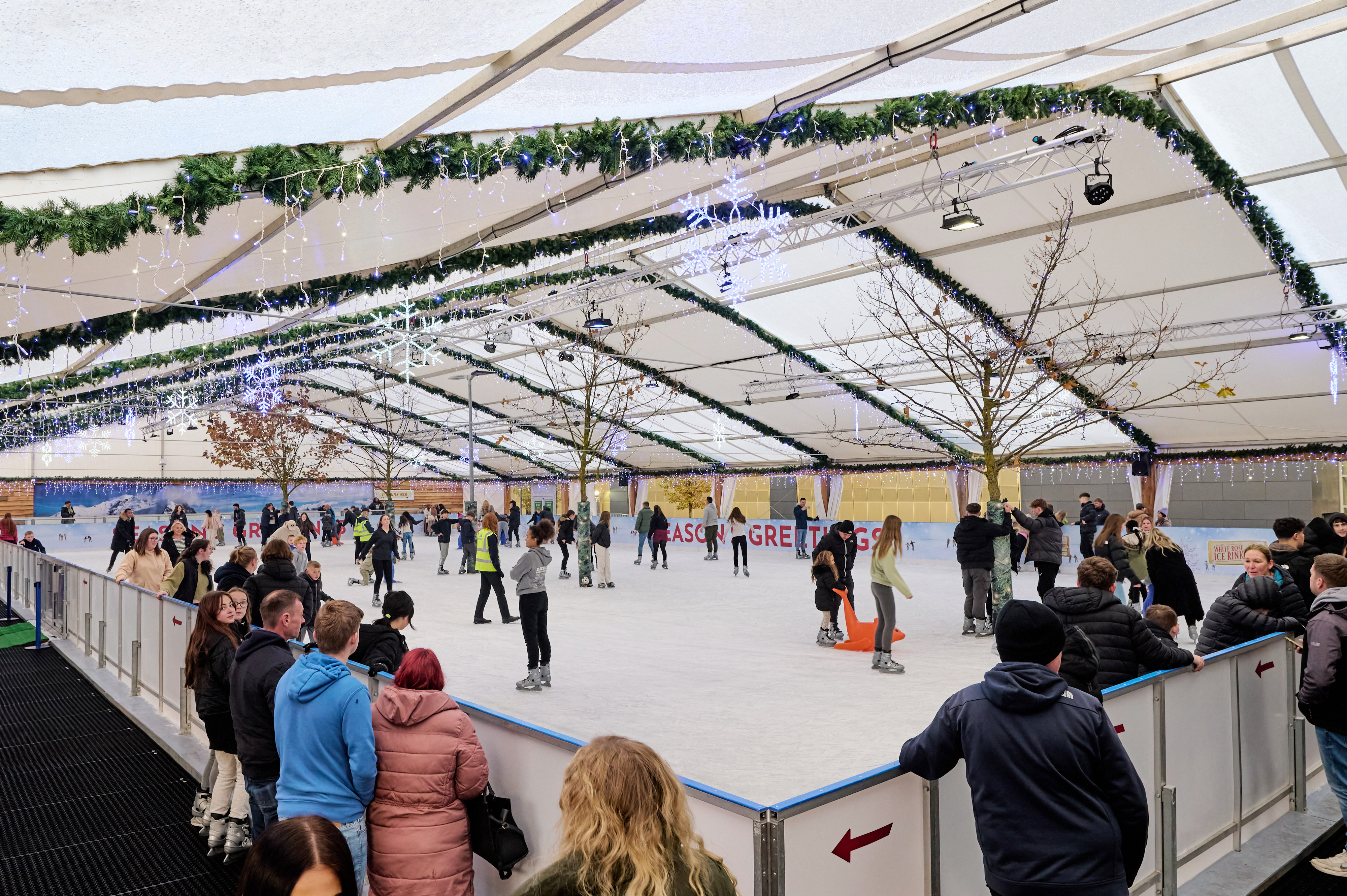 White Rose Shopping Centre, Leeds winter ice rink is filled with skaters enjoying the ice. 
