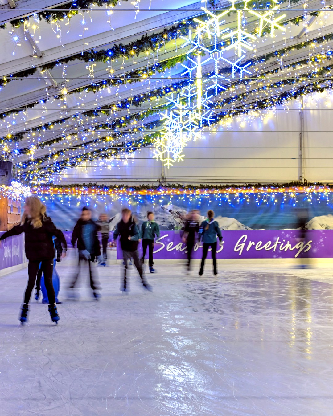 A blurry shot of ice skaters on a winter ice rink 