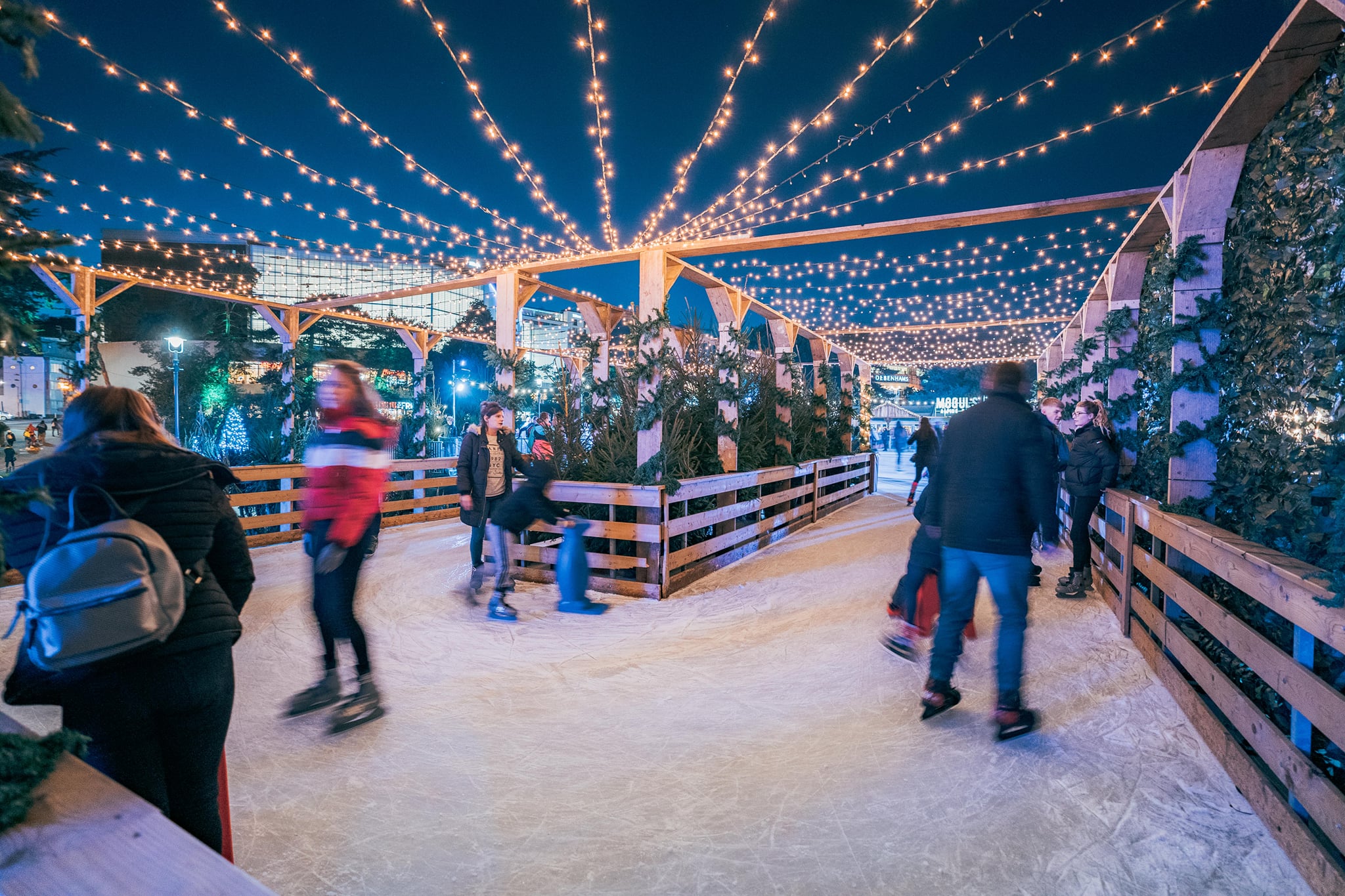 Ice track at Bournemouth Skate. The track is made of wooden barrier and covered with golden festive lights. 