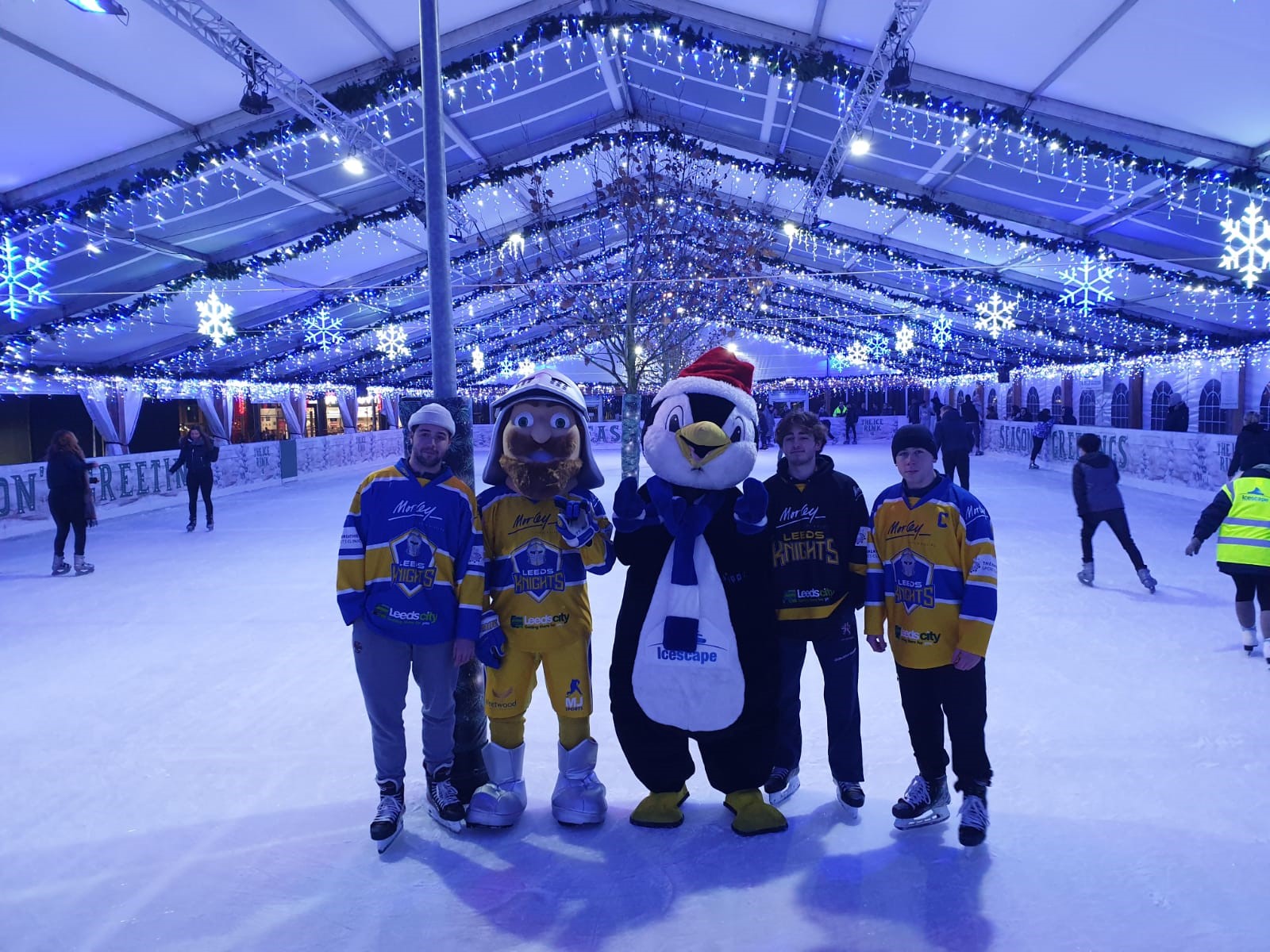The Leeds Knight Mascot, some for the ice hockey players and Pippen the Penguin the Icescape Mascot pose for a photo on the ice. 
