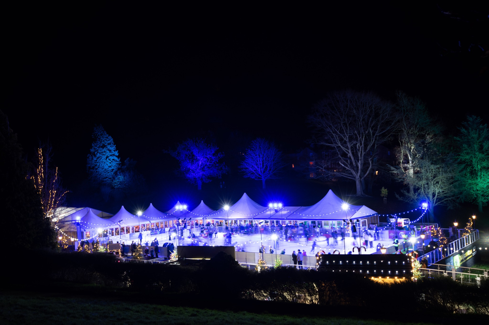 Royal Tunbridge Wells Ice Rink at night. The ice rink is surrounded by marquee coned structures. 